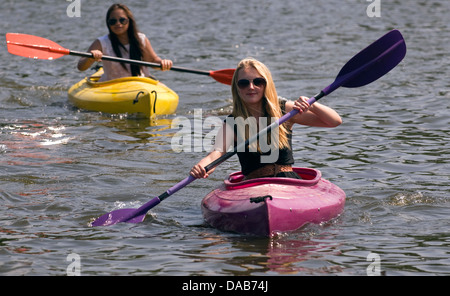 Jeune fille de 15 ans (en premier plan) canoë sur l'étang de lande en été, Petersfield, Hampshire, Royaume-Uni. Banque D'Images