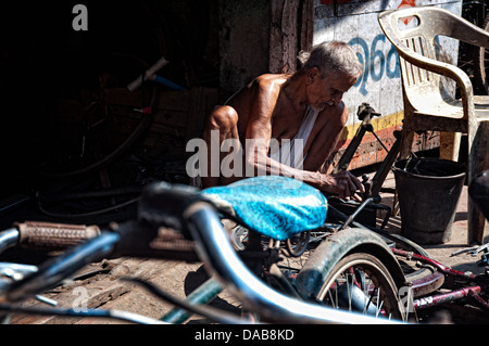 Man fixing bicyclettes dans son atelier. Puri, Orissa, Inde Banque D'Images