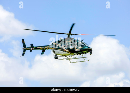 Sarasota Bell Jet Ranger Police Helicopter y perdre passent au-dessus de la ville. Banque D'Images