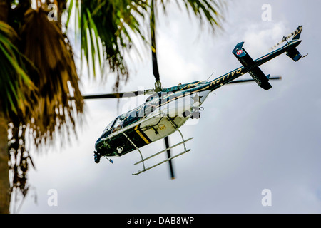 Sarasota Bell Jet Ranger Police Helicopter y perdre passent au-dessus de la ville. Banque D'Images