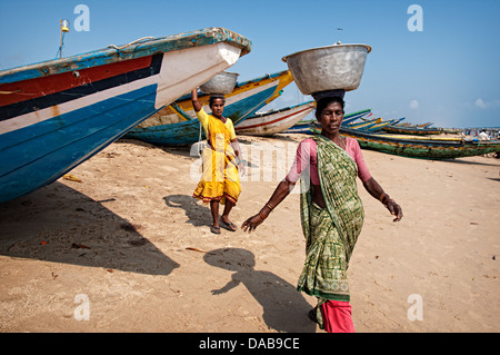 Femme marche parmi les bateaux sur la plage. Puri, Orissa, Inde Banque D'Images