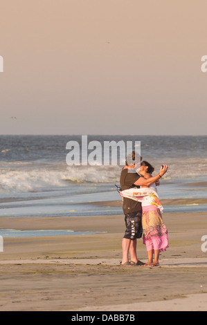 Le partage d'un couple baiser romantique s'embrasser et prendre photo sur Vichayito plage au coucher du soleil, Mancora, Pérou. Banque D'Images