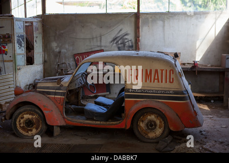 Une vieille voiture portant le logo "Frimatic" dans un garage abandonné à Fayl-Billot, France. Banque D'Images