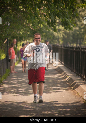 Les amateurs d'exercice courir à Central Park à New York à la mi-journée malgré la chaleur caniculaire Banque D'Images