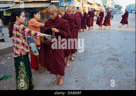 Procession de moines bouddhistes recevoir les offrandes, Mawlamyine (Moulmein), l'État Môn, Myanmar (Birmanie), l'Asie Banque D'Images