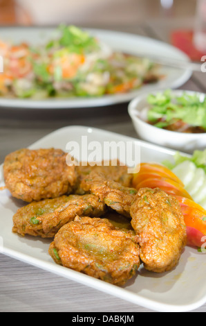 Gâteau de poisson frit épicé (Tod Mun Pla) servi avec tomate et concombre sur plat , thai food Banque D'Images