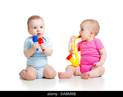 Bébé fille et garçon jouant jouets musicaux. Isolé sur fond blanc Banque D'Images