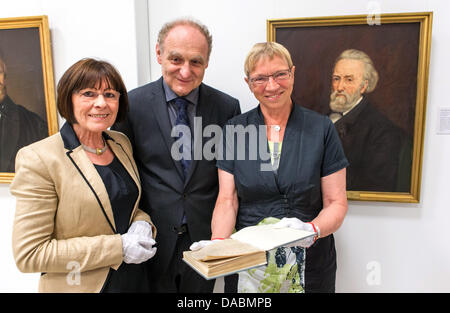 Küchmeister Kornelia, directeur du Département des manuscrits de la bibliothèque de l'État du Schleswig-Holstein, Jens Ahlers, directeur de la bibliothèque d'État de Schleswig-Holstein, et Anke Spoorendonk (SSW), le ministre de la culture du Schleswig-Holstein (L-R), posent avec Hebbel manuscrits de disparition par l'acide et les manuscrits de la restauré roman 'Le cavalier sur le Cheval Blanc' par Theodor Storm à Kiel, Allemagne, 10 juillet 2013. Photo : MARKUS SCHOLZ Banque D'Images