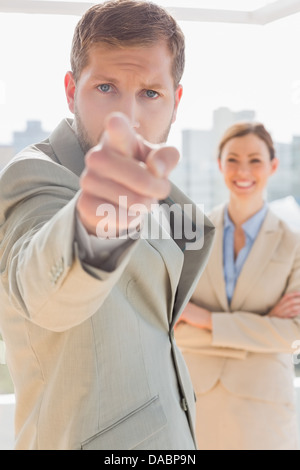 Agacé businessman pointing at camera Banque D'Images
