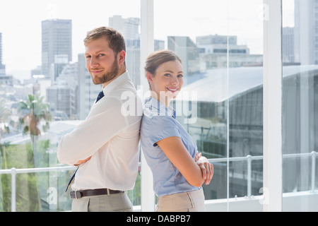 Confident business team standing back to back Banque D'Images