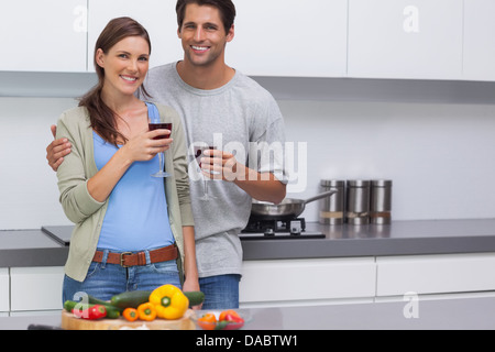 Heureux couple clinking leurs verres de vin rouge Banque D'Images