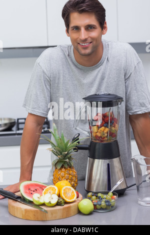 Bel homme se penchant sur le comptoir de sa cuisine Banque D'Images