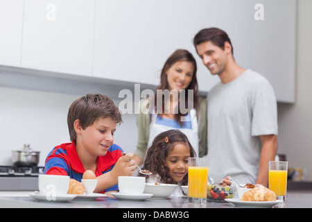 Les enfants ayant le petit déjeuner dans la cuisine Banque D'Images