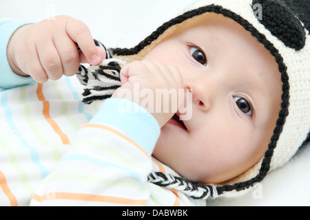 Happy Baby se situe sur le dos sur un lit blanc Banque D'Images