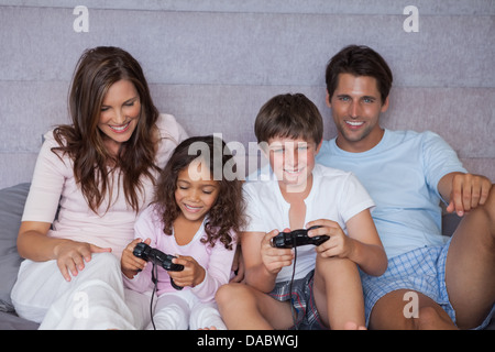 Smiling family playing video games Banque D'Images