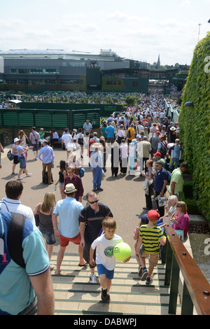 Les gens qui marchent autour de l'ensemble de l'Angleterre au cours de l'année 2013 Club de tennis de Wimbledon tennis center Court dans l'arrière-plan Banque D'Images