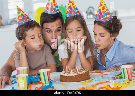 Family blowing candles together Banque D'Images