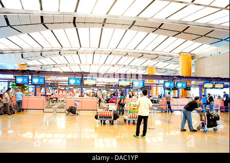 Les gens à l'arrivée au comptoir d'enregistrement à l'Aéroport International de Changi. Banque D'Images