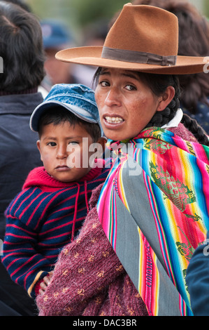 Inca Inca mère femme en couverture traditionnelle et transportant enfant bébé garçon plaza de armas Cusco, Pérou. Banque D'Images