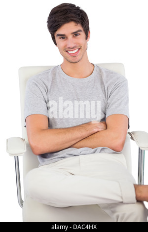 Smiling man with arms crossed assis sur une chaise pivotante Banque D'Images