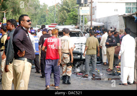 Voir l'après bombe suicidaire attaque contre le président du Pakistan, Asif Ali Zardari, chef de la sécurité de Cheikh Bilal. Les responsables de la sécurité et à l'escouade de neutralisation des bombes sont occupés dans l'inspection de l'étendue des dommages-intérêts après l'attentat suicide, près de Jamia Binoria à Karachi le mercredi, 10 juillet 2013. Au moins trois personnes ont été tuées et 11 autres ont été blessées dans la puissante explosion qui a secoué le quartier Nouvelle ville animée au coeur de Karachi, à moins d'un kilomètre de la mausolée de Quaid. Banque D'Images