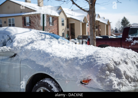 Une voiture dans un appartement stationnement après une tempête de neige Banque D'Images