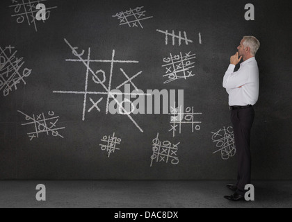 Businessman looking at douteux le tic-tac-toe Banque D'Images