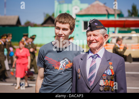 Gomel, Bélarus - 9 mai 2013 : anciens combattants non identifiés avec le petit-fils pose sur un appareil photo lors de la célébration du Jour de la Victoire Banque D'Images