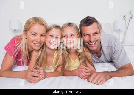 Portrait de parents au lit avec leurs enfants Banque D'Images