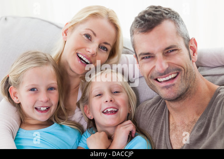 Portrait de parents et les jumeaux assis sur un canapé Banque D'Images