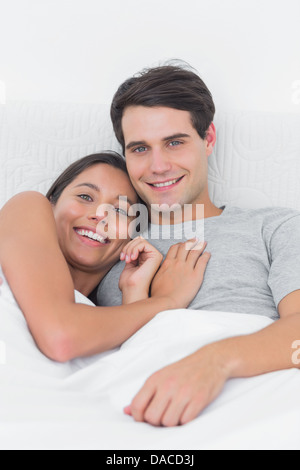 Pretty woman embracing son partenaire au lit Banque D'Images