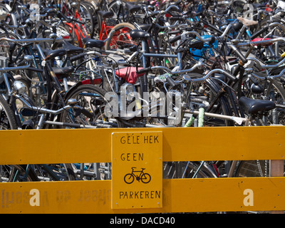 Scène typiquement néerlandais ; pas de stationnement de bicyclettes contre la barrière jaune. La gare centrale de Breda, Pays-Bas Banque D'Images