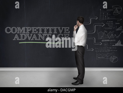 Businessman standing in front of a blackboard Banque D'Images