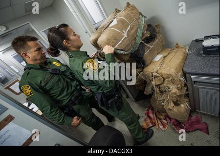 10 juillet 2013 - Nogales, Arizona, États-Unis - U.S. agents de patrouille frontalière inspecter les balles de marijuana, chacun pesant environ 50 livres à l'intérieur des terres semi-permanents de contrôle sur I-19 north de Nogales. Sacs de jute remplis de marijuana sont souvent façonnés en sacs à dos et reportés dans les États-unis (crédit Image : ©/ZUMAPRESS.com) s Seberger Banque D'Images