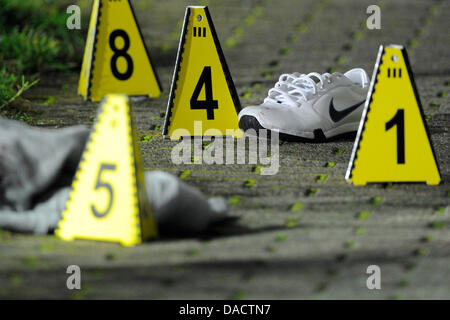 Signe avec les numéros sont situés à côté de la preuve sur la scène de crime à Bottrop, Allemagne, 15 décembre 2011. Peu avant, deux personnes ont été gravement blessés au cours d'une fusillade dans la rue. Selon la police, les deux hommes sont frères à l'âge de 24 et 25. Le motif de la fusillade est encore inconnu et les auteurs sont en fuite. Photo : Marius Becker Banque D'Images