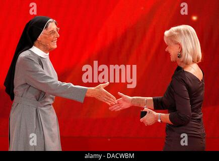 Religieuse catholique Raphaela Haendler (L) reçoit un prix pour son engagement en Afrique de l'actrice britannique Dame Helen Mirren (R) au cours de la 'Ein Herz für Kinder" (Un coeur pour les enfants) TV téléthon Charité à Berlin, le 17 décembre 2011. Photo : Tobias Schwarz dpa  + + +(c) afp - Bildfunk + + + Banque D'Images