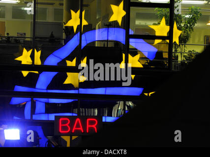 Le signe euro se reflète sur la façade en verre d'un bâtiment au-dessus d'une lettre rouge signe d'un bar en face de la Banque centrale européenne (BCE) à Francfort, Allemagne, le 21 décembre 2011. Selon la BCE, de nombreuses banques de la zone euro a prêté 489 milliards d'euros tous ensemble à partir de la Banque centrale européenne. Le 22 décembre 2011, des experts financiers souhaitent discuter de la situation actuelle Banque D'Images