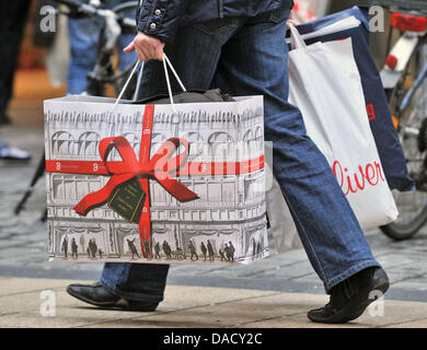 Fichier - une archive photo datée du 23 décembre 2010 montre une femme marche par la zone piétonne avec des sacs de shopping à Leipzig, en Allemagne. Malgré la lenteur du démarrage commerçants allemands sont satisfaits des ventes de Noël en 2011. Photo : Hendrik Schmidt Banque D'Images