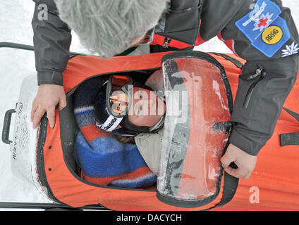 Les membres d'un service de secours en montagne de la Croix-Rouge allemande (DRK) sont illustrés au cours d'un exercice de sauvetage à une pente de ski à Oberwiesenthal, Allemagne, le 19 décembre 2011. Le service de sauvetage en montagne fait face à quelque 550 opérations de sauvetage par saison. Les skieurs et planchistes surtout besoin de l'aide du service. Photo : Hendrik Schmidt Banque D'Images