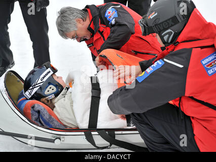 Les membres d'un service de secours en montagne de la Croix-Rouge allemande (DRK) sont illustrés au cours d'un exercice de sauvetage à une pente de ski à Oberwiesenthal, Allemagne, le 19 décembre 2011. Le service de sauvetage en montagne fait face à quelque 550 opérations de sauvetage par saison. Les skieurs et planchistes surtout besoin de l'aide du service. Photo : Hendrik Schmidt Banque D'Images