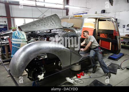 Mécanicien automobile Peter Spillner travaille sur la caisse d'une Mercedes-Benz 770 de 1941 dans son atelier de Glienick, Allemagne, 23 novembre 2011. La société est spécialisée dans la restauration de véhicules historcial. Photo : Nestor Bachmann Banque D'Images