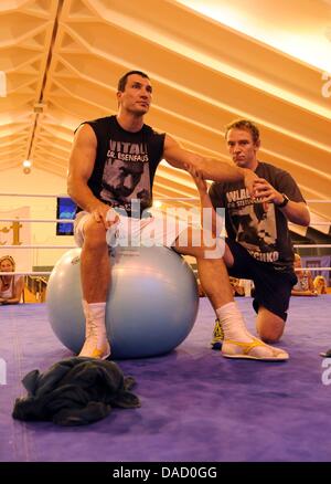 (Afp) - Une archive photo, datée du 24 août 2010, montre le champion du monde de boxe ukrainien Wladimir Klitschko (L) au cours d'une séance d'exercice avec son physiothérapeute Matthias Braunger dans le sport et l'exercice à l'hôtel hall Stanglwirt en allant, en Autriche. Photo : Tobias Hase Banque D'Images