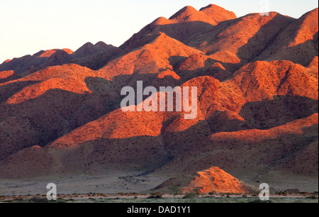 Des montagnes de grès éclairées par les derniers rayons de lumière d'un coucher de soleil, à proximité de Sesriem, Namib Desert, Naukluft Namib, Namibie Banque D'Images