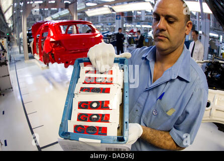 Document - un document photo par Friso Gentsch / Volkswagen montre un membre du personnel de l'presonting la Volkswagen VW logo de la GED à l'usine de Anchieta, Brésil, 03 octobre 2011. La Basse Saxe Premier ministre David McAllister visite l'usine Volkswagen de Anchieta le 04 octobre 2011. Photo : Friso Gentsch / document / EDITORIAL UTILISEZ UNIQUEMENT Banque D'Images