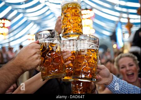 Les visiteurs de la Cannstatter Volksfest toast verres dans une tente du festival à Stuttgart, Allemagne, 07 octobre 2011. Le 166e festival Canstatter Volksfest se termine le dimanche 09 octobre 2011. Les organisateurs estiment à près de quatre millions de visiteurs et 1,5 litres de bière vendus d'ici là. Photo : MICHELE DANZE Banque D'Images