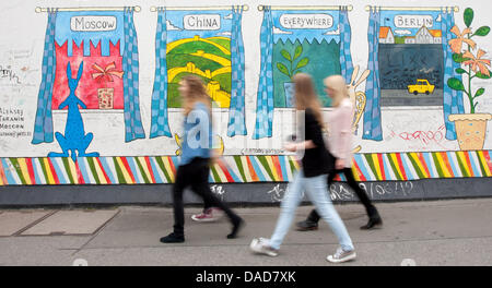 Les jeunes femmes à pied le long de la East Side Gallery à Berlin, Allemagne, 11 juillet 2013. La East Side Gallery est la plus grande galerie en plein air permanent sur la plus longue reste conservé du mur de Berlin en Muehlenstraße entre la gare Ostbahnhof et Berlin Oberbaumbruecke bridge à côté de la rivière Spree. Photo : MARCEL KUSCH Banque D'Images