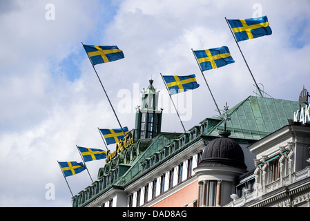 Drapeaux nationaux suédois survolant le toit du Grand Hôtel à Stockholm en Suède Banque D'Images