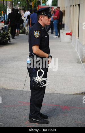 Un policier se tient devant la chambre de Jamie Dimon directeur de banque avec les menottes en plastique à New York, USA, 11 octobre 2011. La maison de la milliardaire était sur la voie d'une démonstration avec les manifestants exigent de plus la taxation des banques et des citoyens riches aux Etats-Unis. Photo : Chris Melzer Banque D'Images