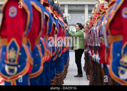 Édition est eine Frau die Uniformen der Wachsoldaten, bevor am Donnerstag (13.10.2011) à Oulan-Bator en der Mongolei Bundeskanzlerin Angela Merkel kommt. Auf dem Programm des Besuchs steht notamment auch der Abschluss von Wirtschaftsverträgen mit der Mongolei. Michael Kappeler afp Banque D'Images