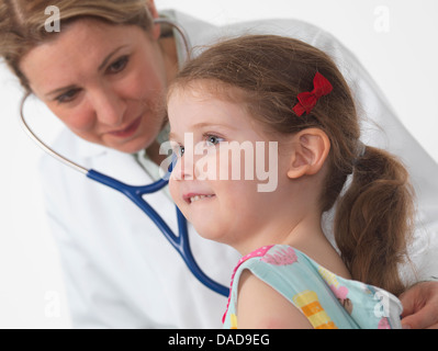 Médecin pédiatrie pour écouter le coeur et les poumons d'une petite fille en chirurgie Banque D'Images